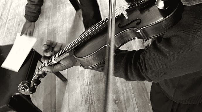 A learner's hands on a violin and bow